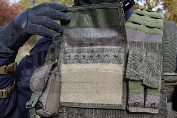 Zbliżenie na przód kamizelki, widoczna kieszeń na granat, panel administracyjny i podwójną ładownicę na magazynki pistoletowe.