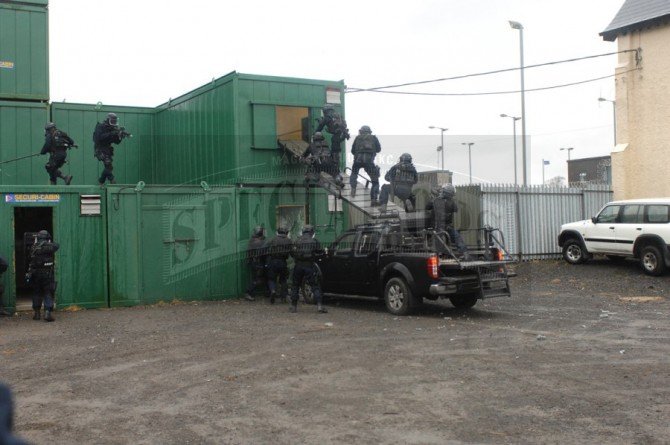 Operatorzy ARW podczas pokazowego odbijania zakładników w swoim taktycznym ośrodku treningowym „Tac town”, z użyciem pojazdu Nissan Navara z rampami szturmowymi.