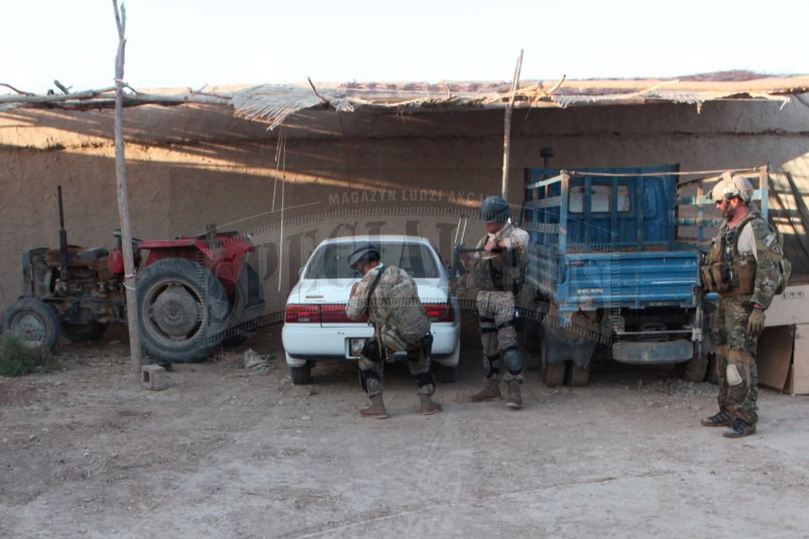 Afgańscy policjanci z National Interdiction Unit CNP-A podczas przeszukiwania pojazdów przy zabudowaniach należących do członków siatki narkotykowej.