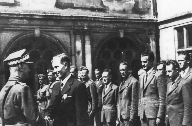 20 sierpnia 1942 r. Gen. Sikorski w ośrodku w Audley End dekoruje krzyżem VM por. „Kawę”, Michała Fijałkę; w ubraniach cywilnych stoją Cichociemni przygotowani do misji (od lewej): kpt. dypl. Wincenty Ściegienny „Las”, kpt. Bolesław Kontrym „Żmudzin”, po.