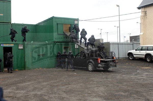 Operatorzy ARW podczas pokazowego odbijania zakładników w swoim taktycznym ośrodku treningowym „Tac town”, z użyciem pojazdu Nissan Navara z rampami szturmowymi.
