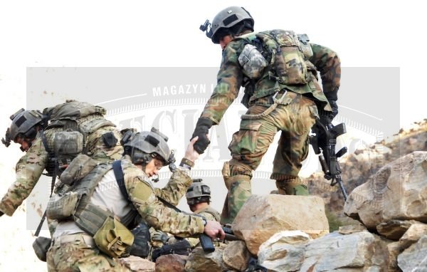 Afgański komandos z żołnierzami amerykańskimi (w kamuflażu Multicam) podczas wspólnego patrolu w górach.