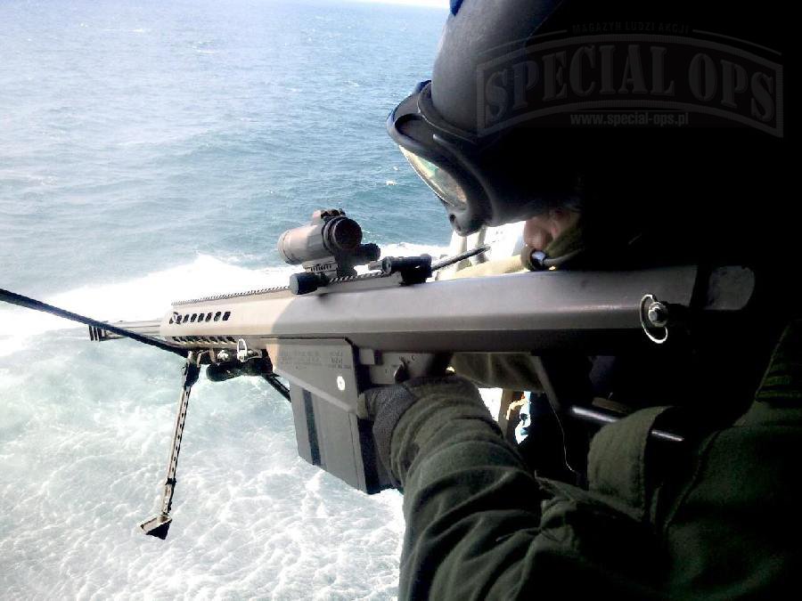 Snajper pododdziału taktycznego TACLET amerykańskiej Straży Przybrzeżnej, przygotowany do zatrzymywania łodzi z pokładu śmigłowca dewastującymi strzałami z Barretta M107 z celownikiem kolimatorowym Aimpoint Comp M4s.