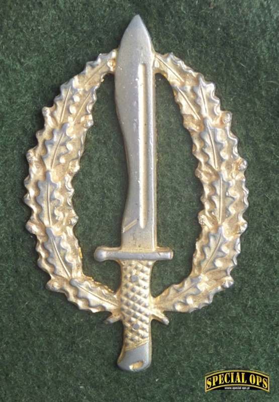 Odznaka guerrilleros: duży nóż machete w wieńcu z liści dębowych.