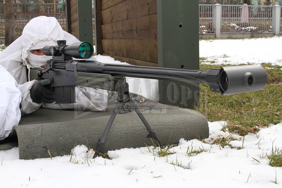 Snajper w wielkokalibrowym brytyjskim AI AW50-FT - poniżej w parze ze strzelcem uzbrojonym w niemiecki HK417