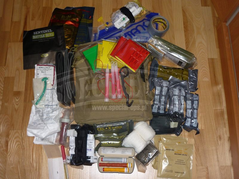 Na zdjęciu jest widoczna część wyposażenia plecaka Raid Pack (Tactical Medical Solutions): zestaw do segregacji ze światłami chemicznymi koloru czerwonego, stazy taktyczne CAT (Combat Application Torniquet), opatrunki uciskowe The Emergency Bandage (Firs.