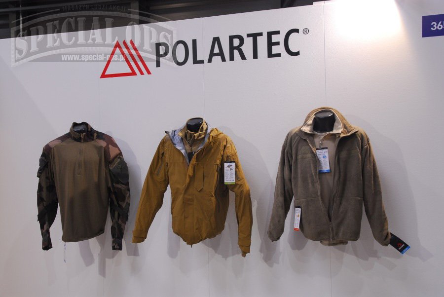 Fragment stoiska firmy Polartec LLC - pośrodku kurtka GARM All Weather Jacket z dzianiny Neo Shell.
