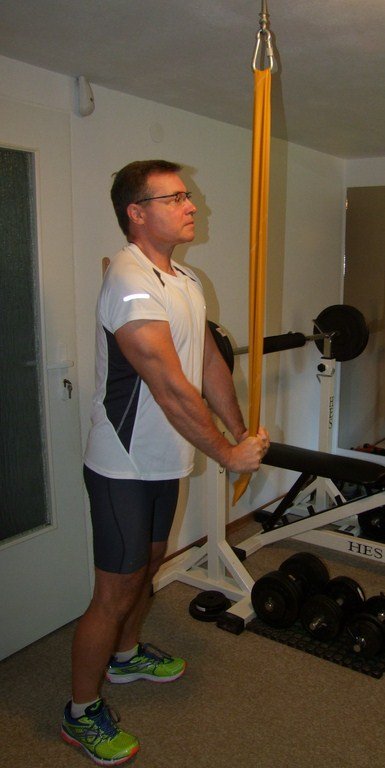 Fot. 4. Uginanie przedramion w dół – ćwiczenie izolowane na mięśnie trójgłowe ramion z wykorzystaniem taśmy elastycznej w odcinku . Doskonałe ćwiczenie do „dopompowania” tricepsów. Uczucie „palenia” jest charakterystyczne dla tego ćwiczenia.