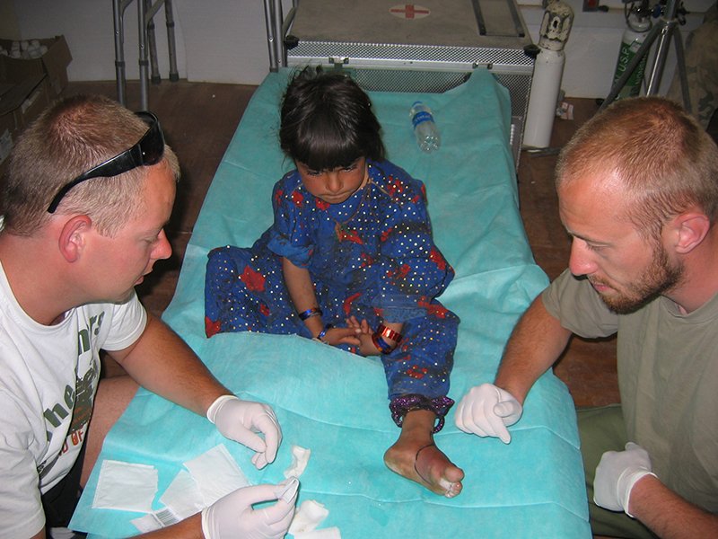Ratownicy medyczni opatrujący dziecko
