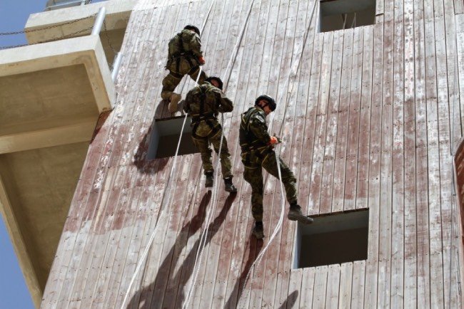 grupa żołnierzy wspinająca się po ścianie