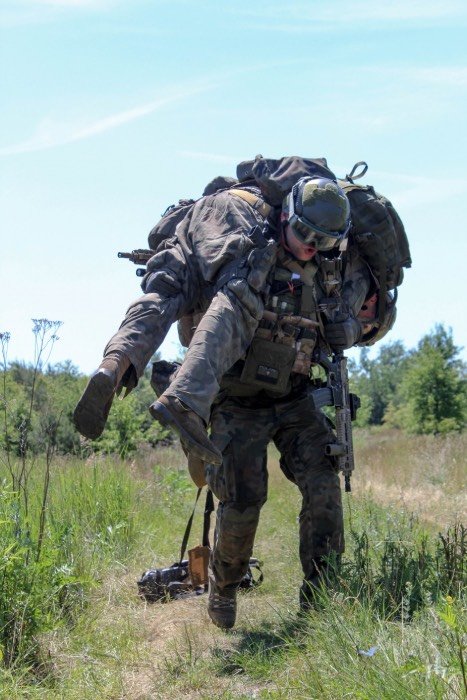 żołnierz niosący poszkodowanego na plecach