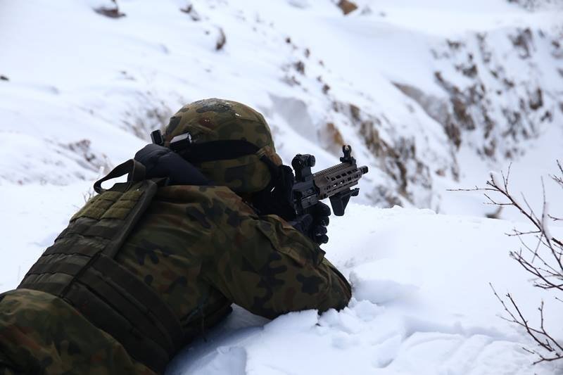 żołnierz strzelający do celu w górach