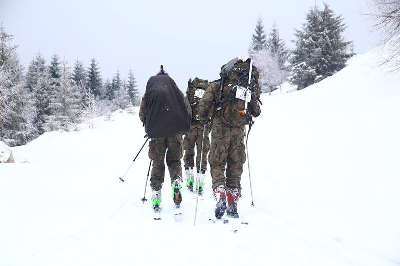 żołnierze z plecakami w górach zimą