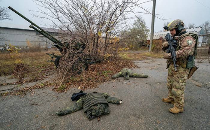 Ukraiński żołnierz oglada porzucony przez rosjan ekwipunek
