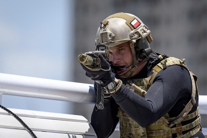operator w hełmie mierzy z broni