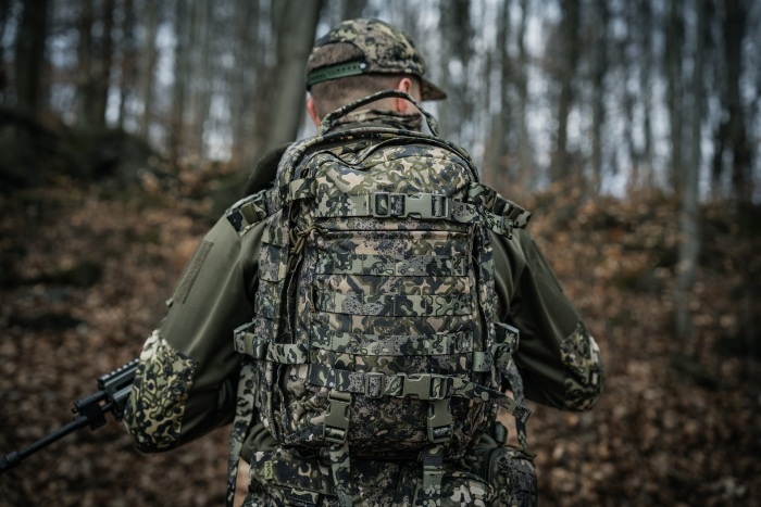żołnierz w umundurowaniu i z plecakiem w lesie