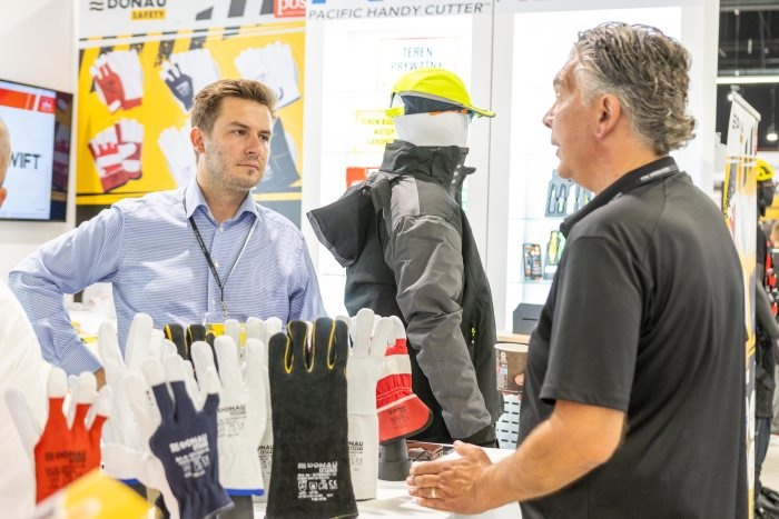 dwie osoby rozmaiwają na stoisku na targach