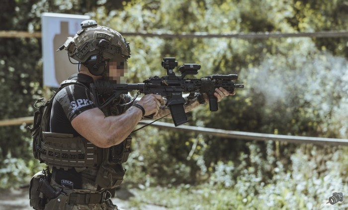 żołnierz z karabinem w lesie