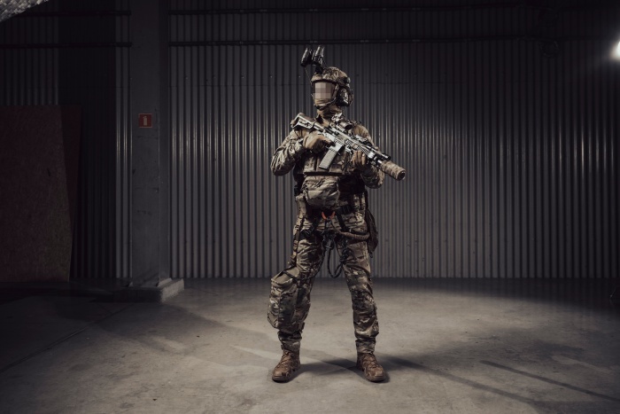 żołnierz w umundurowaniu i oprządzeniu na ciemnym tle