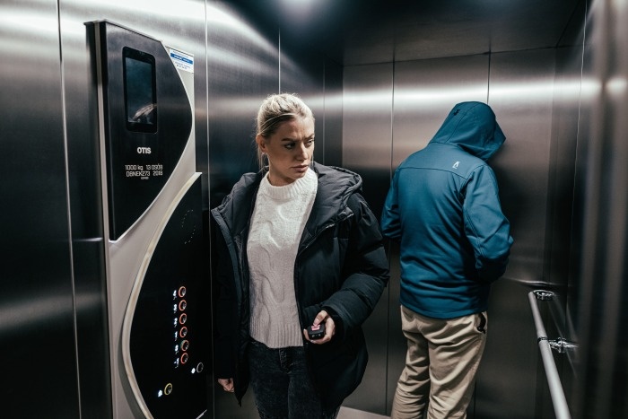 kobieta i mężczyzna w kapturze w windzie