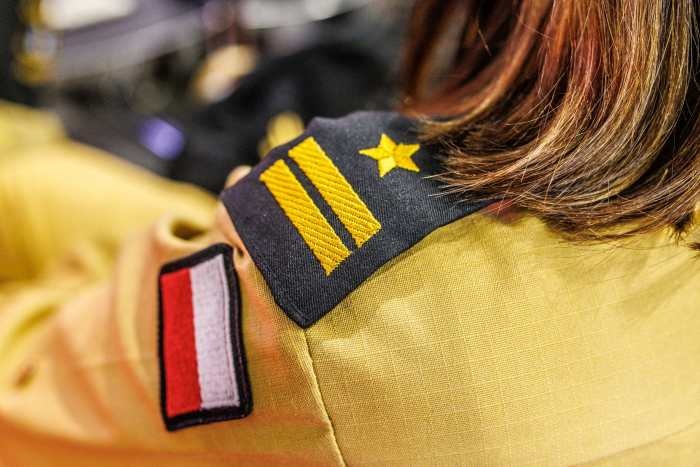 naszywki na tle żółtej koszuli na ramieniu