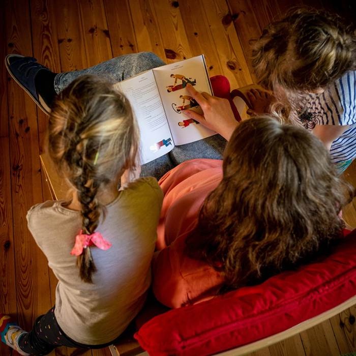 rodzina uczy się z ksiażki o pierwszej pomocy i sytuacjach kryzysowych