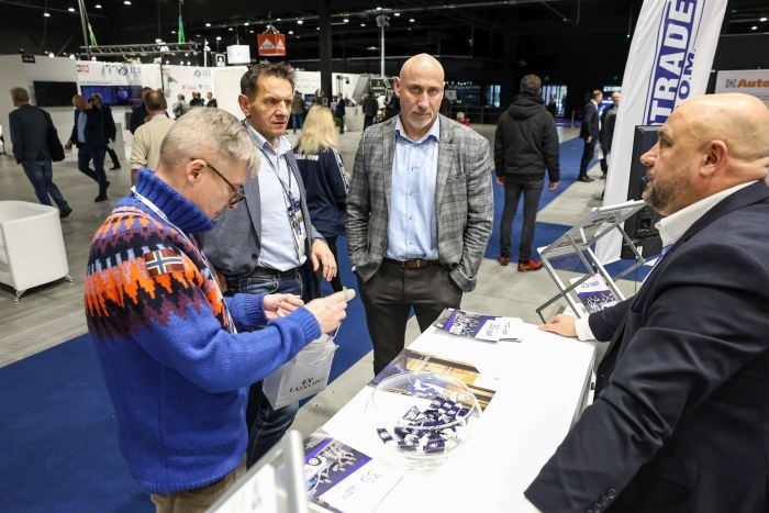 odwiedzający targi bezpieczeństwa oglądają produkty na stoisku