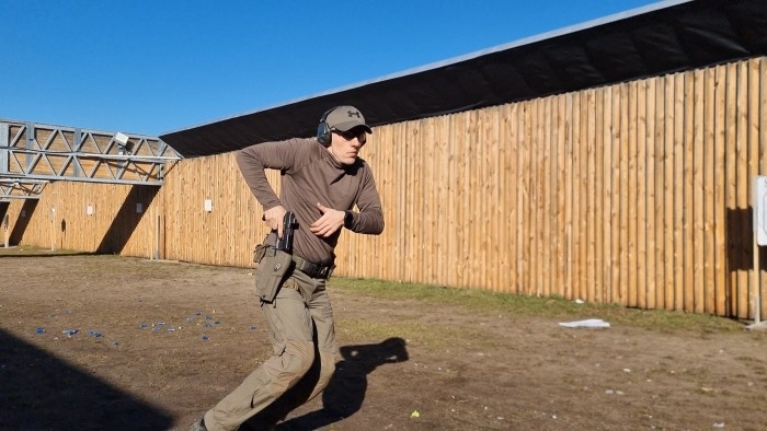 strzelec dobywa broni z kabury na poligonie
