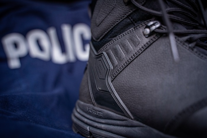 zbliżenie na tył buta i napis policja w tle
